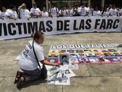 Un grupo de personas protesta frente al Foro Nacional sobre víctimas en Cali.