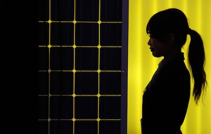 La silueta de una mujer, frente a un panel de energía solar en Tokyo. Más de 600 compañías de 18 países toman parte de esta feria dedicada a la energía solar fotovoltaica.