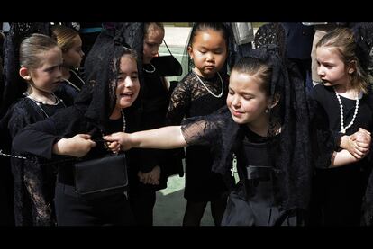 Dos niñas pelean por un bolso durante la procesión celebrada en un colegio de Sevilla, previa a la Semana Santa.