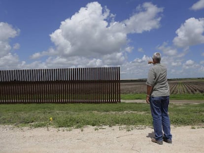 Un hombre se&ntilde;ala un tramo de la valla fronteriza en Brownsville (Texas) en una imagen de 2005