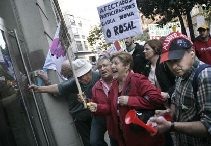 Afectados por las preferentes intentan entrar por la fuerza en una oficina de Novagalicia Banco.