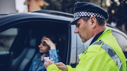 Una mujer es infraccionada por un policía. 