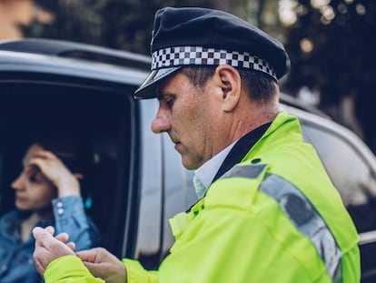 Una mujer es infraccionada por un policía. 