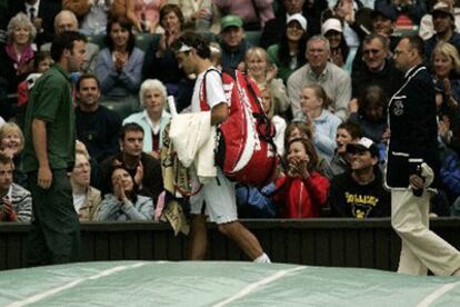 Federer abandona la pista central de Londres después de que la lluvia cancelara el partido que disputaba contra Richard Gasquet.