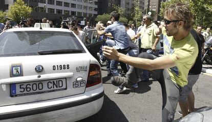 Algunos taxistas que participan en la manifestación arremeten contra un colega que no secundaba la protesta en Madrid.