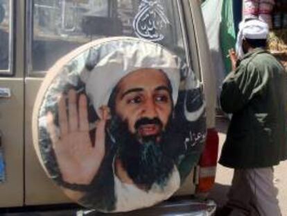 Un hombre pasa junto a un cartel del fundador de la organización terrorista Al Qaeda, Osama bin Laden. EFE/Archivo