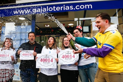 Vecinos y trabajadores de la administración número 5 de Sant Boi de Llobregat (Barcelona) celebran el segundo premio en la Lotería de Navidad.
