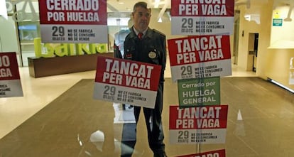 Un guarda de seguridad protege la entrada de la oficina de la sede de Bancaja en Valencia.