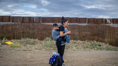 Una mujer migrante porta un bebé a la espalda en Arizona, Estados Unidos.