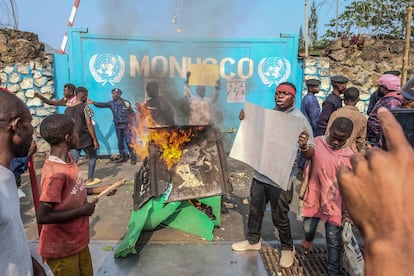 Un manifestante sujetaba el lunes un cartel en el que se lee "Monusco, lárgate" ante la entrada del complejo de la misión de 'cascos azules' de la ONU, en Goma. El lunes, la manifestación inicialmente pacífica contra la misión degeneró cuando una turba penetró en el cuartel general de Naciones Unidas en Goma rompiendo ventanas y escalando las paredes, antes de saquear las instalaciones y de prender fuego al menos a una garita de vigilancia.