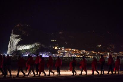 Inmigrantes subsaharianos caminando hacia el Centro de Atención Temporal de Extranjeros desde el muelle situado en Crinavis, San Roque. A su espalda el Peñón de Gibraltar.