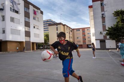 Un niño jugando al fútbol en una plaza de Cádiz.