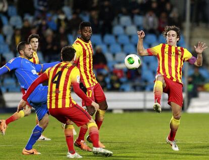El defensa del F. C. Barcelona, Carles Puyol (d), intenta despejar un balón ante el centrocampista argelino del Getafe, Mehdi Lacen (i), durante el encuentro correspondiente a la vuelta de los octavos de final de la Copa del Rey que disputan esta noche en el Coliseum Alfonso Pérez de Getafe.