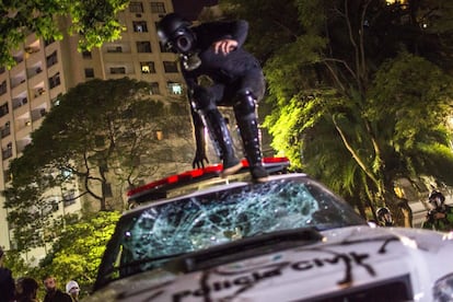 Un manifestante salta sobre un vehículo policial durante la protesta en São Paulo (Brasil).