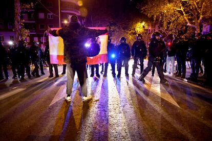Un manifestante se enfrenta a la policía con una bandera de España, en la que se ha recortado el escudo.