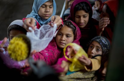 Niñas reciben comida en un centro de distribución en un barrio pobre de Islamabad (Pakistán).