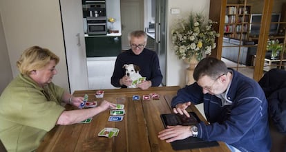 Artur Shouten y Toni Smit juegan a las cartas mientras Ennekens usa su tableta.