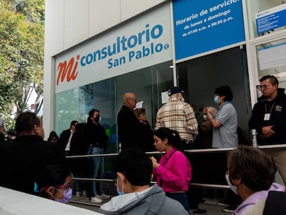 Personas esperan afuera de un consultorio de las Farmacias San Pablo, el 20 de diciembre en Ciudad de México.