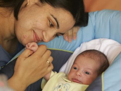 Cristina Mora Palomo, superviviente del 11-M, mira a su hija Arantxa, recién nacida.