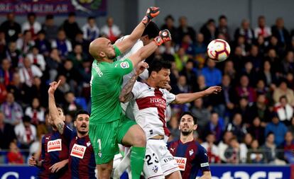 Marko Dmitrovic, portero del Eibar, disputa la pelota a Damián Musto, centrocampista del Huesca.