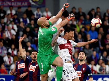 Marko Dmitrovic, portero del Eibar, disputa la pelota a Damián Musto, centrocampista del Huesca.