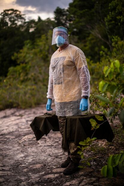 El biólogo Marcelo Gordo sostiene dos jaulas para monos en un bosque tropical integrado en la ciudad brasileña de Manaos.