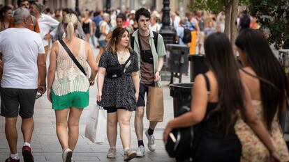 Clientes paseando este domingo por el portal de l'Àngel de Barcelona, donde este verano las tiendas abren en festivo.