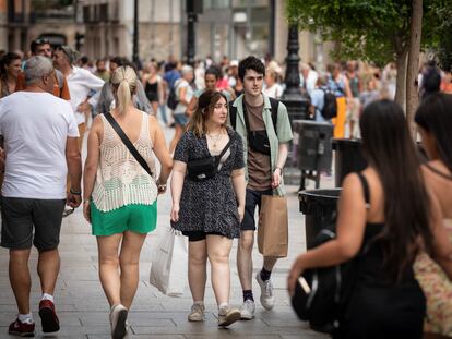 Clientes paseando este domingo por el portal de l'Àngel de Barcelona, donde este verano las tiendas abren en festivo.