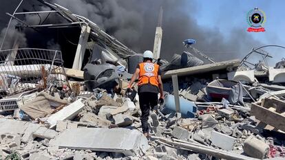 Un trabajador de la Defensa Civil de Gaza busca supervivientes en un edificio bombardeado en Jan Yunis, el viernes.
