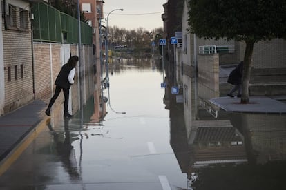 Un vecino de la localidad navarra de San Adrián cruza una calle inundada este martes.