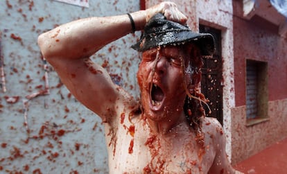 Un participante de la fiesta de la Tomatina cubierto de pulpa de tomate, en Buñol (Comunidad Valenciana).