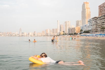 Miluzka Arias, organizadora del Bus Playero Viajero, descansa sobre un flotador en la playa de Benidorm durante el amanecer del sábado.