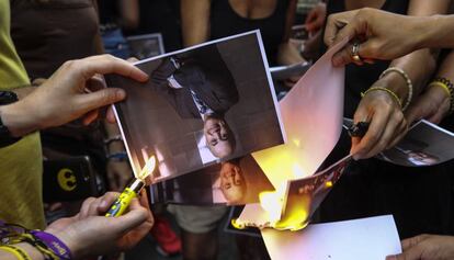 Several pro-independence protesters burn photos of Judge Pablo Llarena.