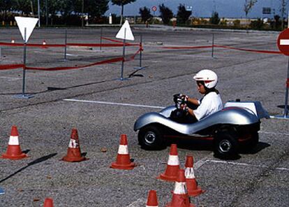 Un niño conduce un <i>kart</i> en un circuito durante el desarrollo de un curso de seguridad vial infantil organizado por la casa de automóviles Audi.