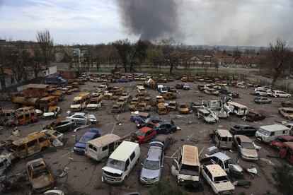 Vehículos dañados y quemados se ven en una parte destruida de la planta metalúrgica Illich Iron & Steel Works, mientras el humo se eleva desde el combinado metalúrgico Azovstal durante los intensos combates en un área controlada por las fuerzas separatistas respaldadas por Rusia en Mariupol.