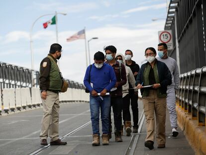 Un grupo de migrantes es escoltado por agentes del Instituto Nacional de Migración en Ciudad Juárez (México), en noviembre de 2020.