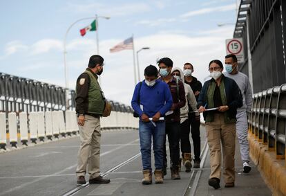 Un grupo de migrantes es escoltado por agentes del Instituto Nacional de Migración
