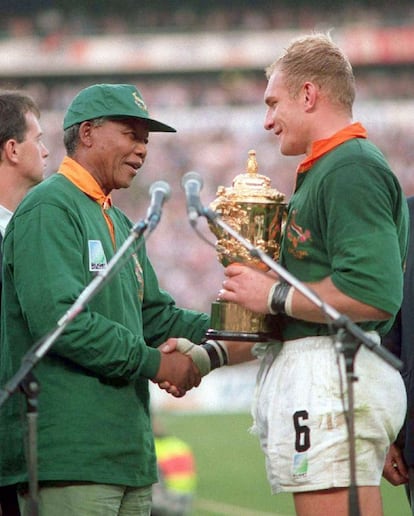 O presidente da África do Sul, Nelson Mandela, entrega a taça do Mundial de rúgbi ao capitão da seleção de seu país, François Pienaar, depois de ganhar da Nova Zelândia em Johannesburgo, em 24 de junho de 1995.