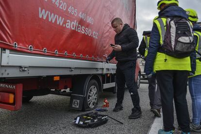 Un transportista canvia una roda punxada del seu vehicle durant el tall de l'AP-7 a Salt, aquest dimecres.