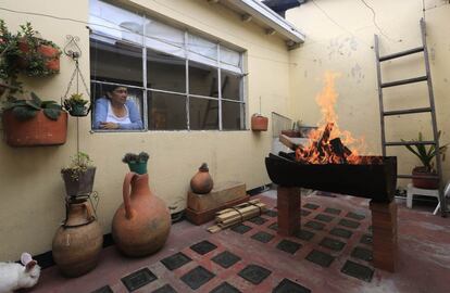 Rebeca Ruiz observa desde la ventana de su casa de Bogotá (Colombia) una barbacoa improvisada en el patio de la vivienda con un antiguo barril. La foto se tomó el 14 de febrero.