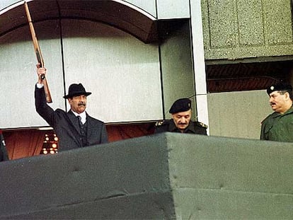 Sadam Husein dispara con un rifle para dar la salida a un desfile militar en Bagdad, en diciembre de 2000.