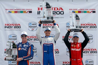 Winner Alex Palou, center, second-place finisher Scott Dixon, left, and third-place finisher Will Power, right, raise their trophies in Victory Lane after an IndyCar auto race at Mid-Ohio Sports Car Course in Lexington, Ohio, Sunday, July 2, 2023.