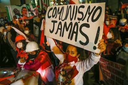 Una manifestante en contra de la elección de Pedro Castillo sostiene una pancarta