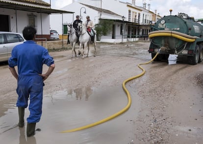 Un operario recoge agua con el camión cisterna en una calle de la aldea almonteña de El Rocio (Huelva), tras las intensas lluvias que se vienen registrando desde el pasado viernes y que se prevé se prolonguen mañana y el jueves.