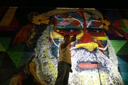 Un autóctono se saca una fotografía frente a otro de los murales con que Kobra decoró la ciudad a las puertas de celebrar sus primeros Juegos Olímpicos (Río de Janeiro, Brasil).