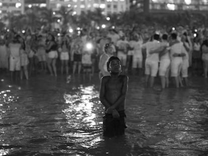 Um menino observa os fogos na virada de ano novo em Copacabana.