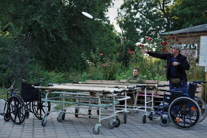 Un sanitario militar juega al frisbie con un compañero a la espera de recibir a compañeros heridos en un hospital improvisado a unos kilómetros del frente de Zaporiyia.