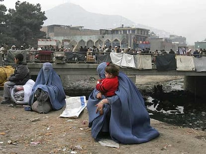 Mujeres afganas esperan un transporte ayer en Kabul.