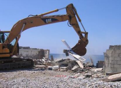 Una excavadora derriba una de las 14 casetas para barcas construidas en una zona protegida de Ibiza.