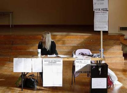 Una de las integrantes de una mesa electoral espera la llegada de votantes en un colegio en Dublín.